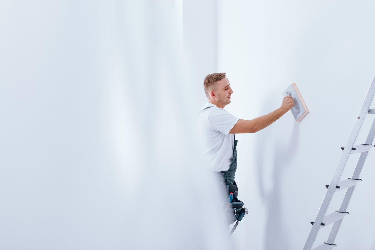 handyman cleaning a white wall